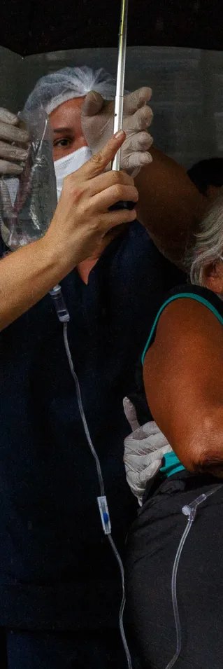 En kvinna med covid-19 bärs till ambulans för vidare transport till flygplatsen och därifrån till sjukhuset i Manaus, Brasilien. 