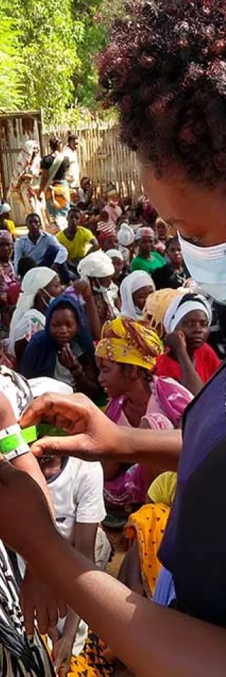 En kvinna från Läkare Utan Gränser mäter överarmen på ett litet barn med måttbandet MUAC i Meluco , provinsen Cabo Delgado i Moçambique.