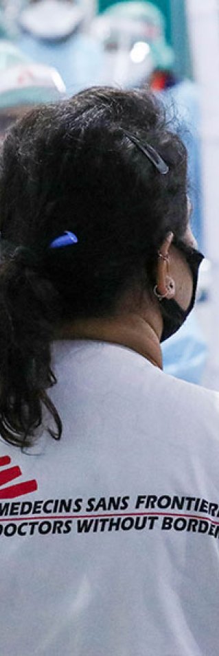 Läkaren Nisha Mohan står med ryggen mot kameran och pratar med personal på vårt  temporärt sjukhus i Patna, Indien.