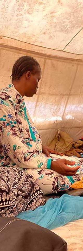 Safi Keita, som är gravid, sitter i ett tält tillsammans med andra kvinnor i Assamaka, Niger.