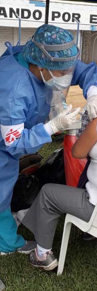 Personal från Läkare Utan Gränser vaccinerar en kvinna i Peru mot covid-19.