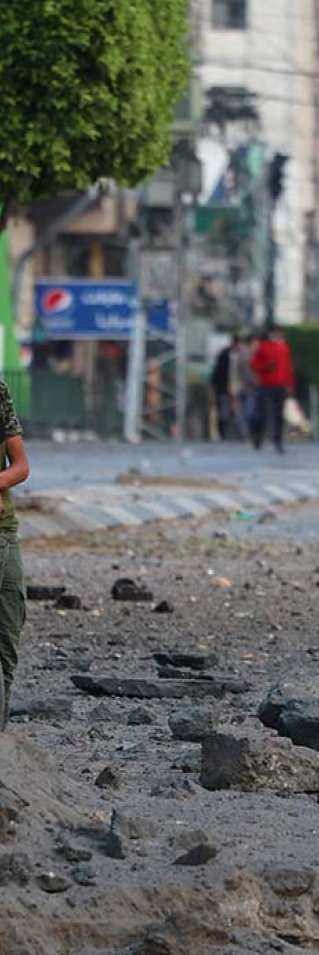 En palestinsk man i närheten av al-Sharouk tornet i Gaza, som inrymde TV-kanalen al-Aqsa, som förstördes i en israelisk flygattack, i Gaza City, den 13 maj.