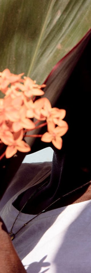 En kvinna i Centralafrikanska republiken håller en blomma framför sitt ansikte.