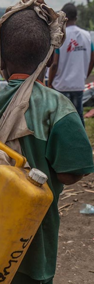 Ett barn i Sake bär på en vattendunk, efter vulkanen Nyiragongos utbrott i Kongo-Kinshasa