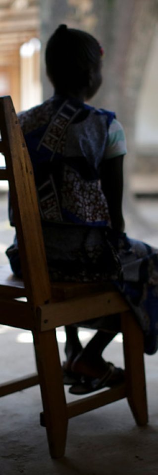 En kvinna i Centralafrikanska republiken sitter i en gungstol med ryggen mot kameran.