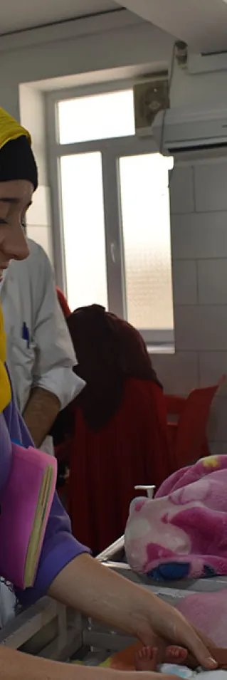 Sjuksköterskan Kimberly Morris tittar till en nyfödd bebis på mödravårdssjukhuset i Khost, Afghanistan. 