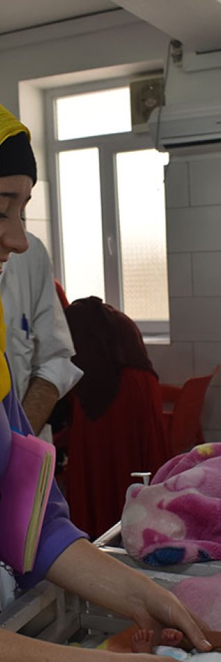 Sjuksköterskan Kimberly Morris tittar till en nyfödd bebis på mödravårdssjukhuset i Khost, Afghanistan. 