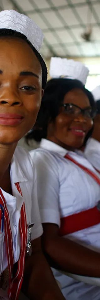 Sjuksköterskor och barnmorskor sitter på rad vid en examensceremoni i Sierra Leone.