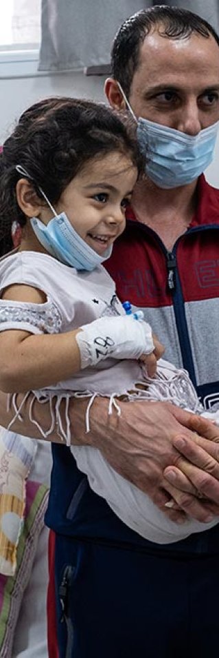 Fembarnspappan Mohammed Aboud bär sin fyra år gamla dotter Hala som har gips på höger fot, på al-Awda sjukhus i norra Gaza, Palestina. 