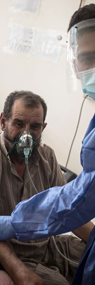 En sjukvårdsanställd tittar till en patient som får syrgas på sjukhuset i Raqqa i nordösta Syrien. 