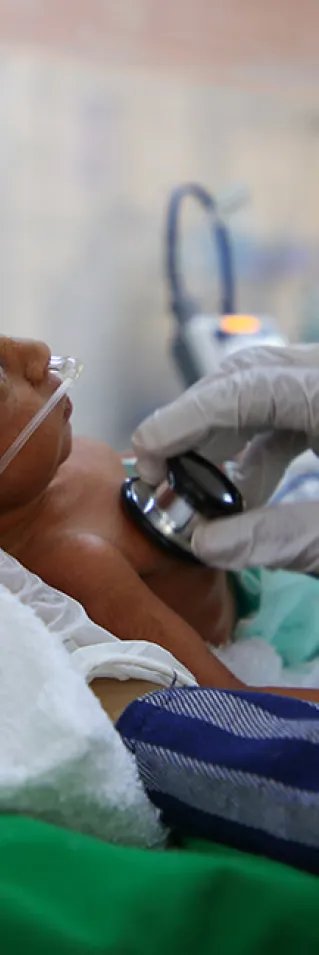 Sjukvårdspersonal lyssnar med stetoskop på en liten bebis på al Jamhouri sjukhus i Taiz City, Jemen.