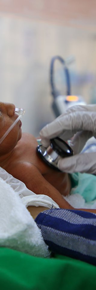 Sjukvårdspersonal lyssnar med stetoskop på en liten bebis på al Jamhouri sjukhus i Taiz City, Jemen.