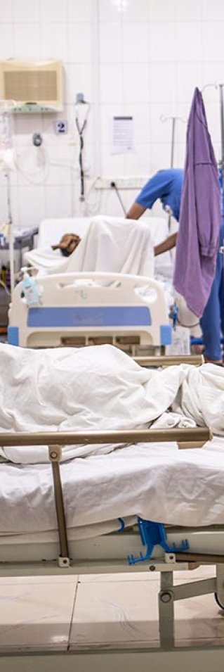 Ett barn ligger med ryggen mot kameran i en sjukhussäng på Aden sjukhus i Jemen.