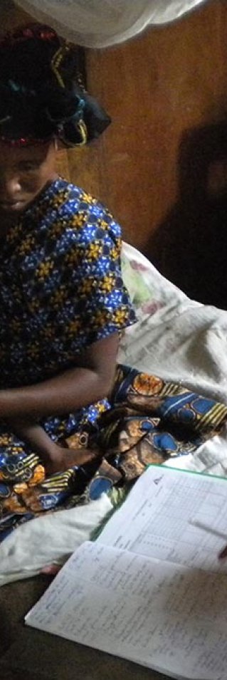 Läkaren Jennifer Turnbull sitter på en säng på Mweso sjukhus i Kongo-Kinshasa. På andra sidan sängen sitter en mamma med sitt lilla barn.