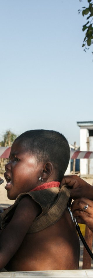 En man ger ett näringsberikat kex till sin femåriga dotter som är undernärd. Samtidigt undersöker en kvinnlig läkare barnet med ett stetoskop. Undersökningen sker under bar himmel i södra Madagascar.