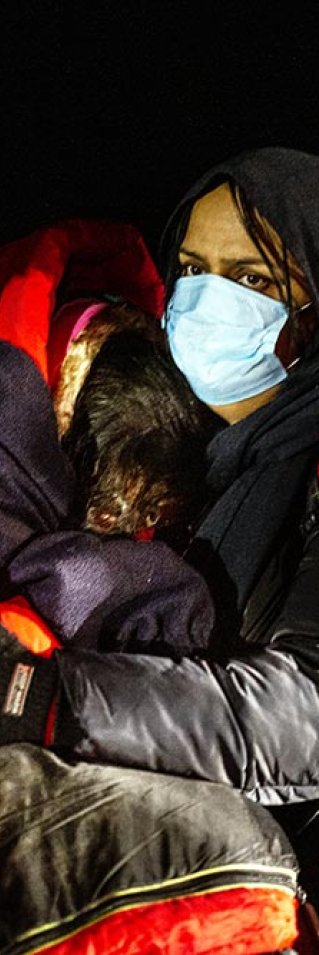 En mamma från Irak kramar sina döttrar, någonstans vid gränsen mellan Polen och Belarus