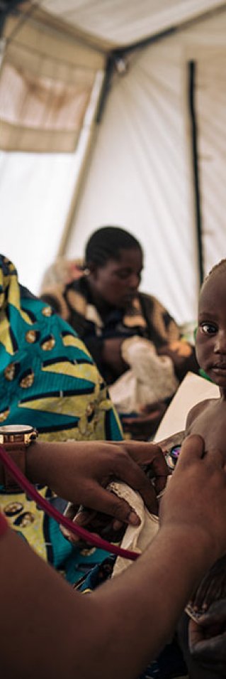 Läkaren Benjamin Safari undersöker elva månader gamla Emeriane i i flyktinglägret i Rhoe, Kongo-Kinshasa.