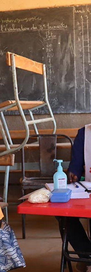 En pojke, som står bredvid sin mamma, träffar personal från Läkare Utan Gränser på en mobil klinik i Titao, Burkina Faso. 