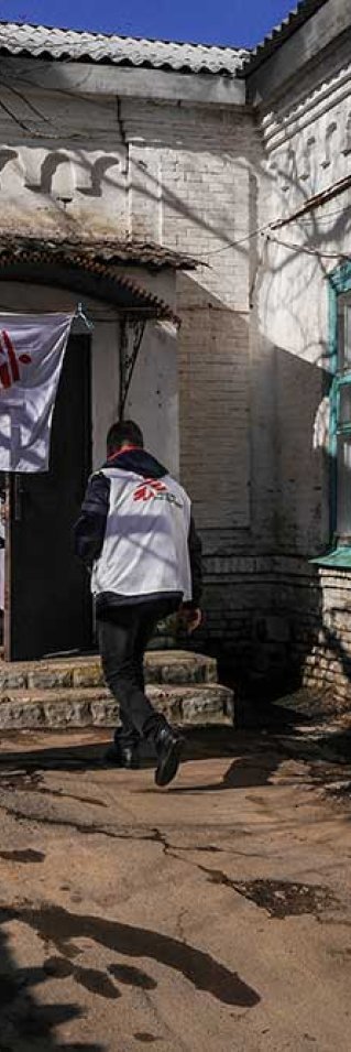 En anställd från Läkare Utan Gränser går in i ett hus i byn Starohnativka, Ukraina.