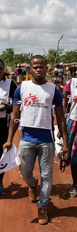 Tre hälsoinformatörer från Läkare Utan Gränser går på en gata i delstaten Ebonyi i sydöstra Nigeria.