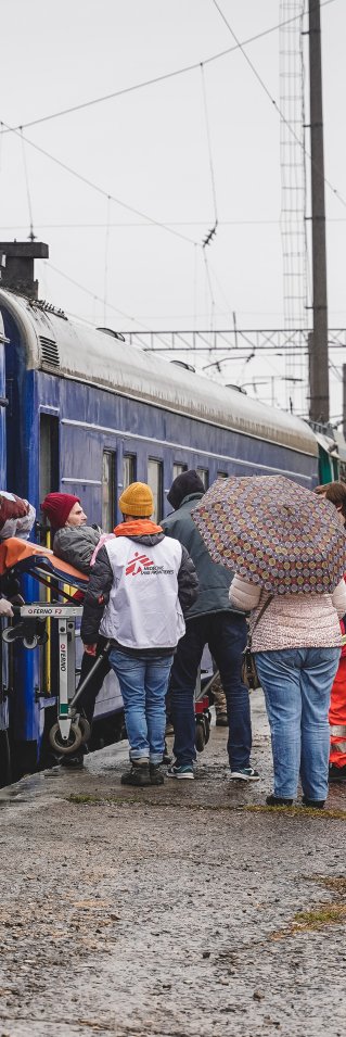 En patient som ligger på en bår förs över från ett tåg till en ambulans i Lviv, Ukraina. 