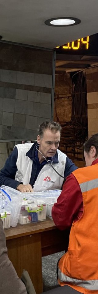 Läkaren Morten Rosrup sitter vid ett bord i Charkivs tunnelbana där Läkare Utan Gränser ger grundläggande vård och stöd.