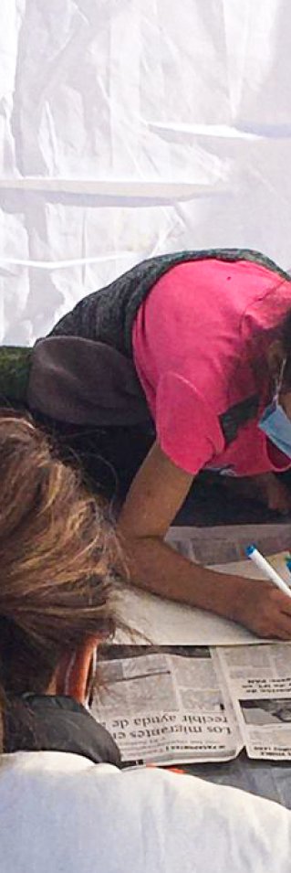 En medarbetare från Läkare Utan Gränser sitter med tre flickor och ritar i Mexiko.