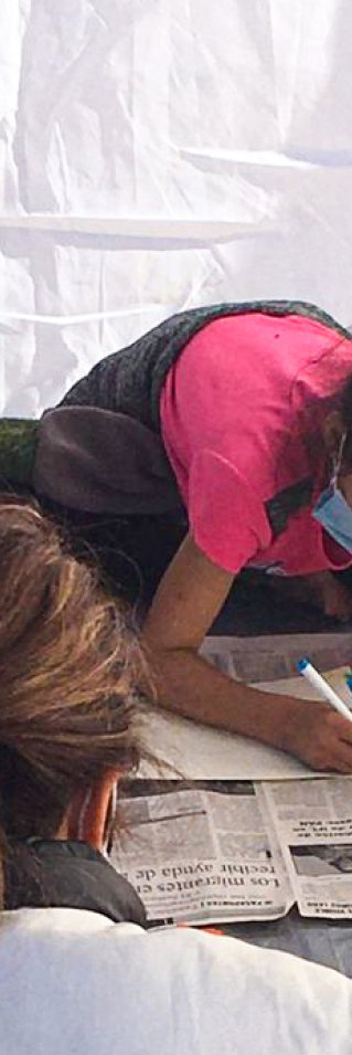 En medarbetare från Läkare Utan Gränser sitter med tre flickor och ritar i Mexiko.