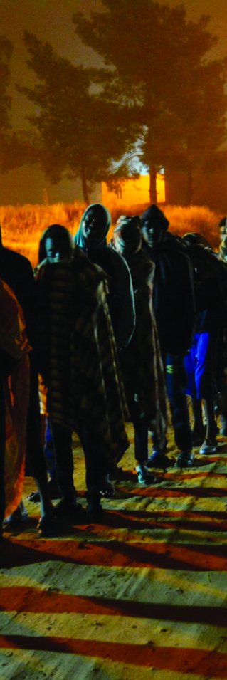 Människor köar för att få mat vid Dhar el-Jebel-förvaret i Libyen. 