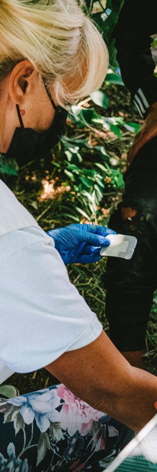 En sjuksköterska lägger om ett sår på en mans knä