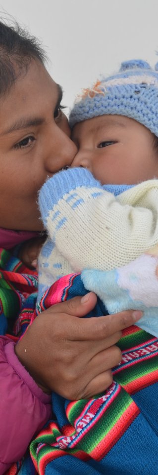 Mamma pussar sitt barn på kinden.