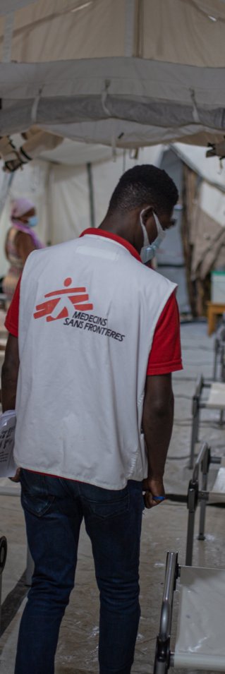 En hälsoinformatör tittar till patienterna i ett kolerabehandlingcentret.