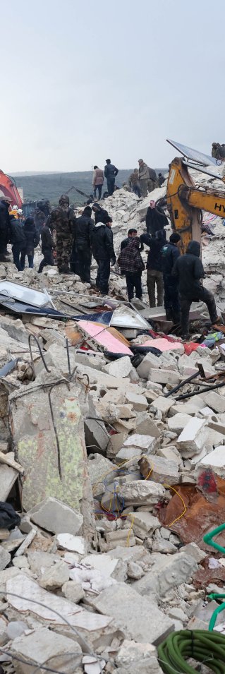 En grävskopa gräver i rasmossorna efter en stora jordbävning som drabbade Turkiet och Syrien.
