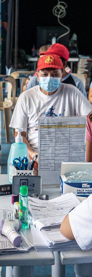 Personer sitter runt ett bord. Närmast bild sitter två personer i Läkare Utan Gränser t-shirt.
