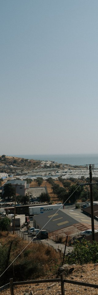 Silutten av en person med keps ses kolla ut över havet framför hen.