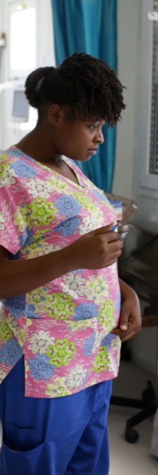 Sjuksköterskan Gessica i Haiti talar med en patient som ligger i en sjukhussäng
