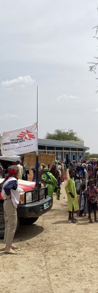 jeepar och människor i ett flyktingläger för sudaneser i Tchad