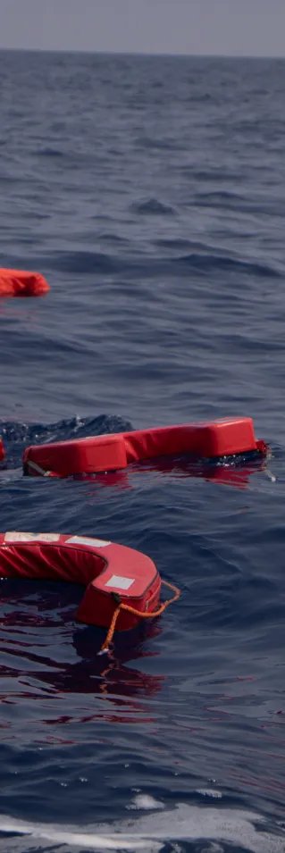 Flera flytvästar flytter på ett öppet hav med inga båter i bakgrunden