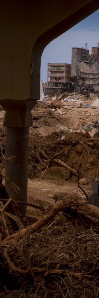 raserade byggnader och en gata full av lera och bråte som översvämningar lämnat efter sig