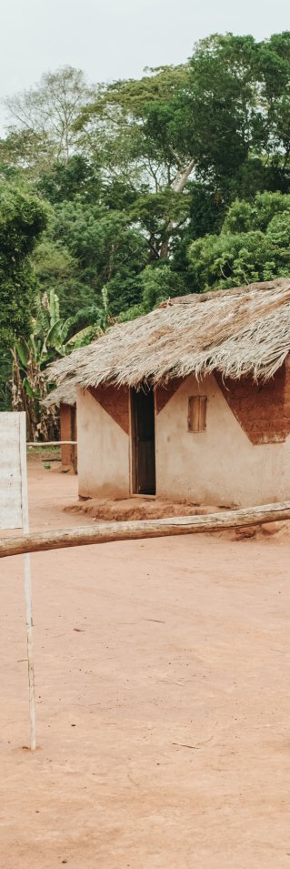 Ett litet hus byggt av tegelstenar syns bakom en vit skylt i ett stepplandskap