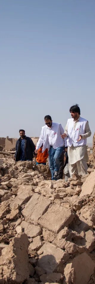 Tre medarbetare från Läkare Utan Gränser går över stora rasmassor efter jordbävningen i Afghanistan