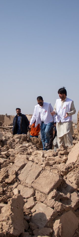 Tre medarbetare från Läkare Utan Gränser går över stora rasmassor efter jordbävningen i Afghanistan