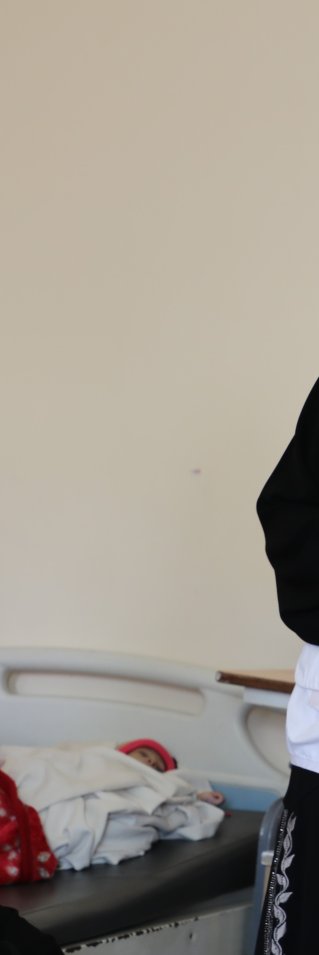 En kvinna med Läkare Utan Gränser-väst och munskydd står vid en säng där en annan kvinna sitter. Till höger ser man en illustration av en familj som sitter på en filt och äter. 