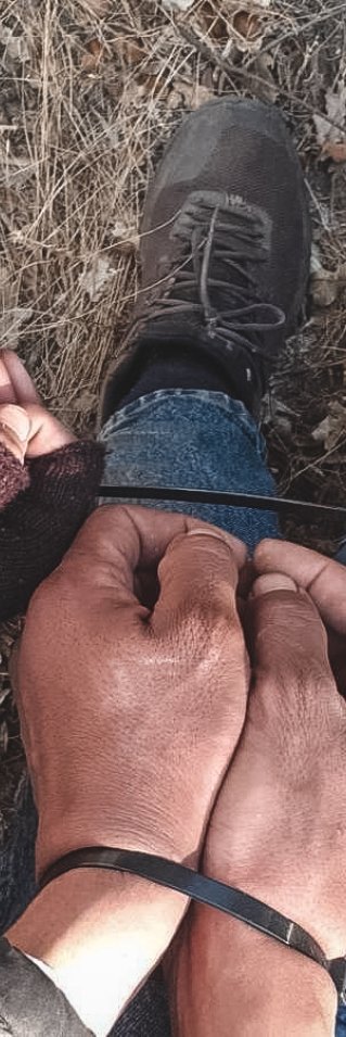 Närbild på flera par smutsiga händer som är ihopbundna med buntband