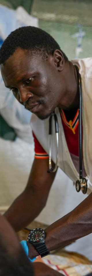 Läkare i Läkare utan gränser väst står böjd över en patient