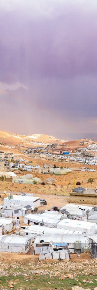 Vy över Arsal, vita hus och berg syns.