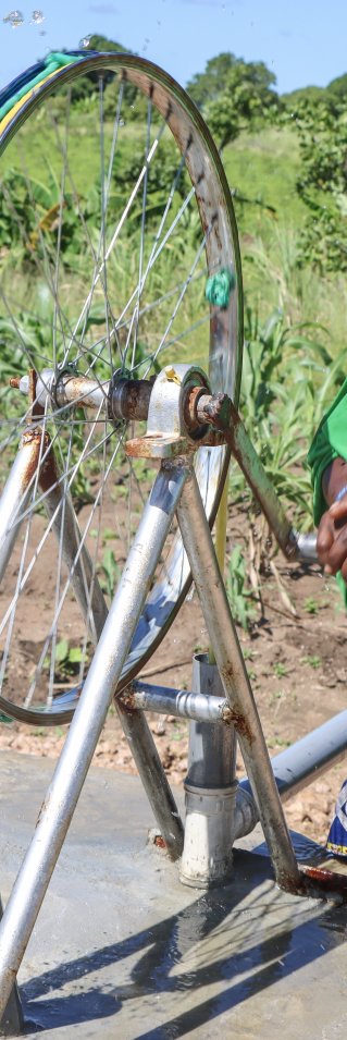 En kvinna pumpar vatten från en brunn 