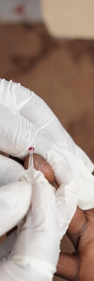 Närbild på händer när ett blodprov tas i finger