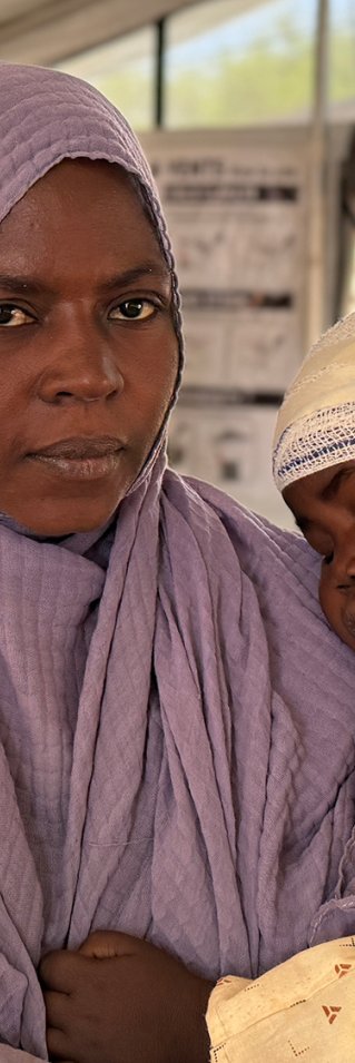 Kvinna håller i barn med bandage runt huvudet