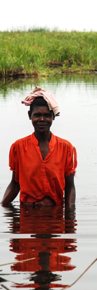 Kvinna vadar med barn som ska vaccineras mot mässling